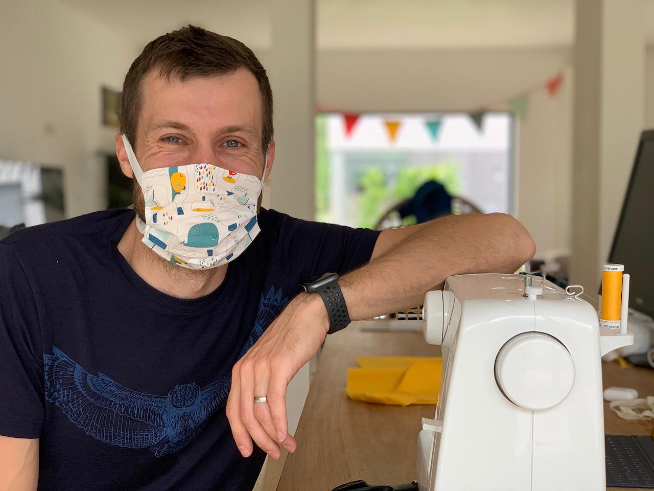 Joren showing his face mask with sewing machine